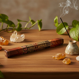 Incense smoking in burner, with box of incense on table with plants and crystals